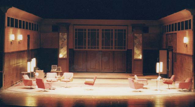 DER GETEILTE HIMMEL Volksbühne Berlin, Bühne Alissa Kolbusch. Ein leerer brauner DDR- Salon mit hinten 2 Säulen und vielen 60er Jahre DDR_Cocktail- Sesseln und Stehlampen.